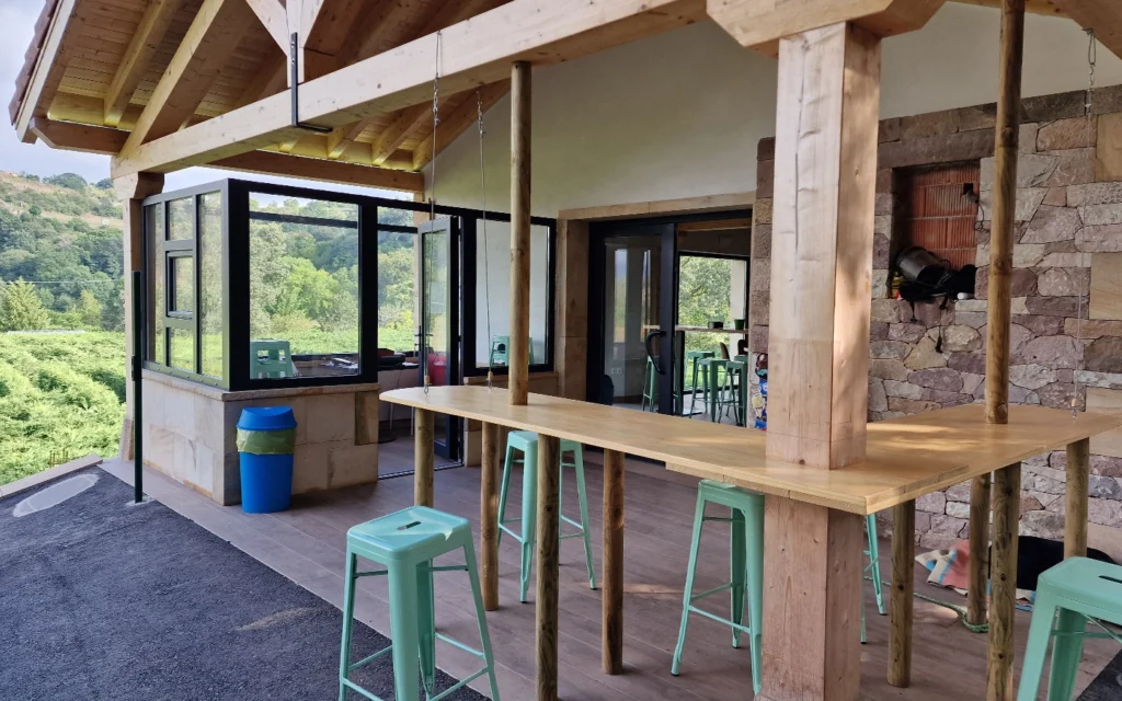 Entrada de una cafetería de madera y piedra en un entorno natural